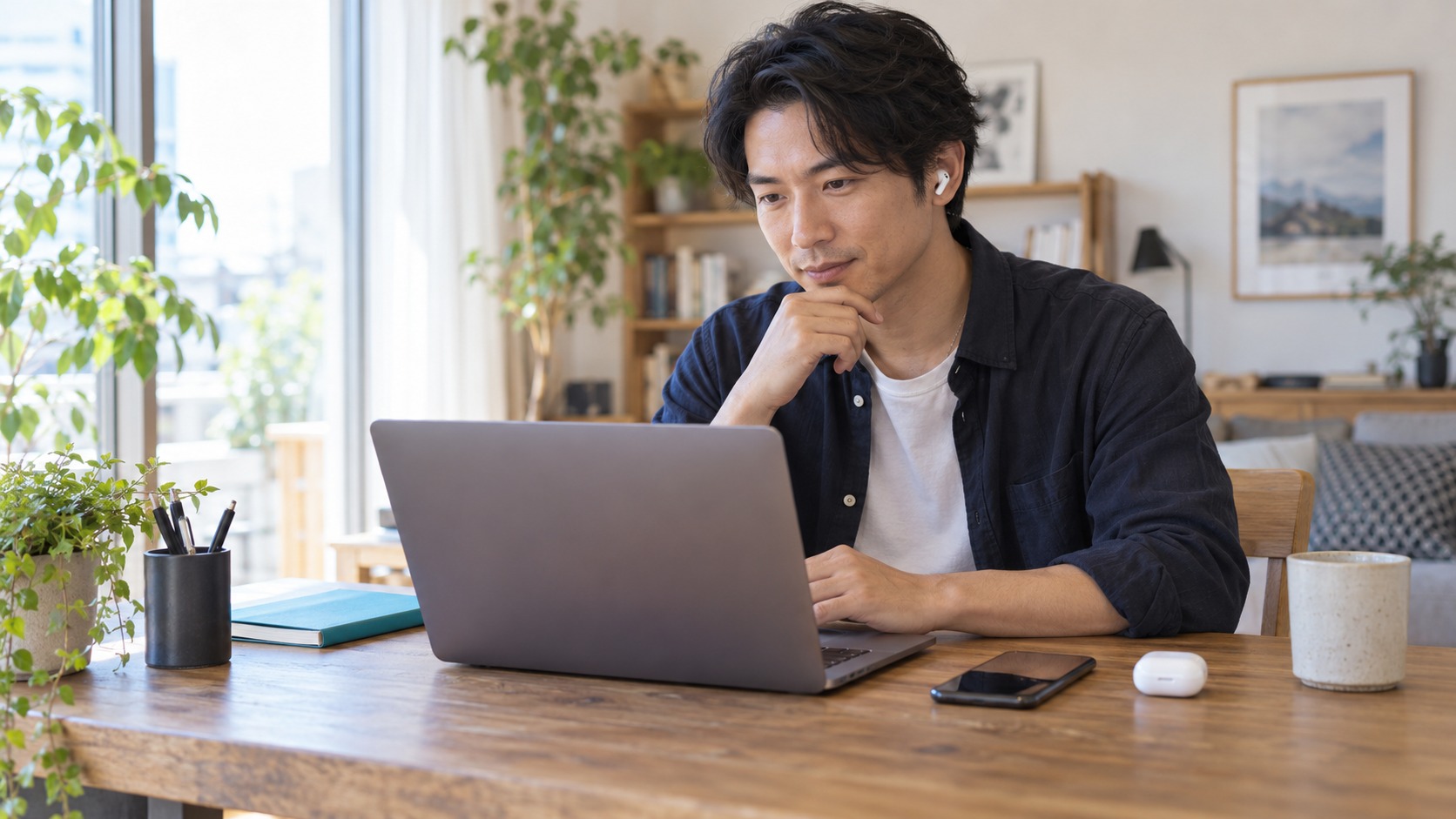 自宅のPCでイヤホンを使って会話する男性の実写風イメージ